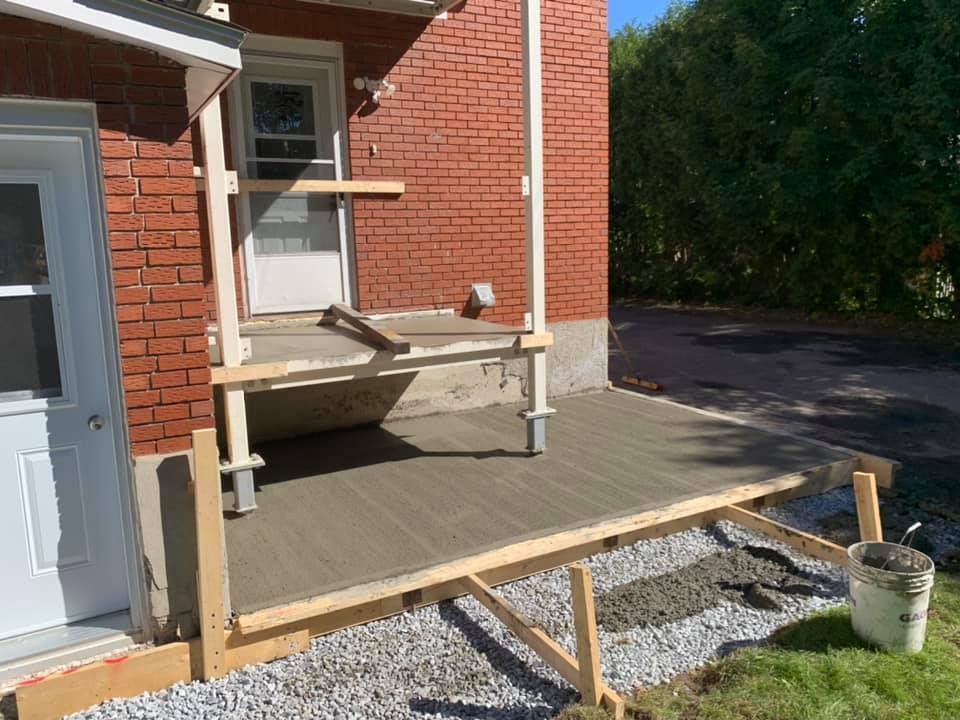 Un porche est en cours de construction devant une maison en briques.