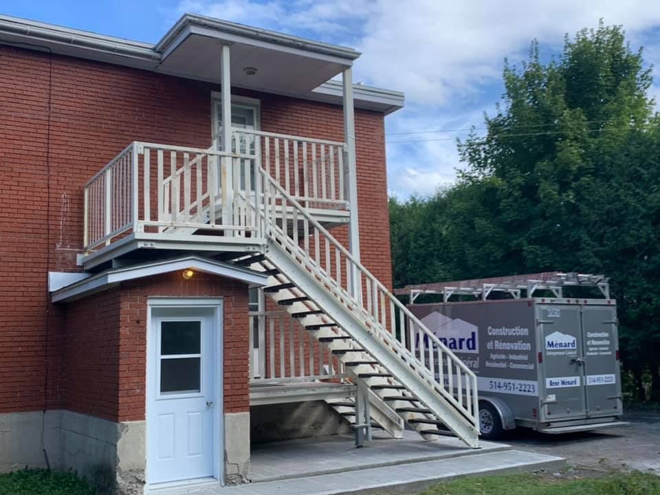 Un bâtiment en briques avec des escaliers menant au deuxième étage