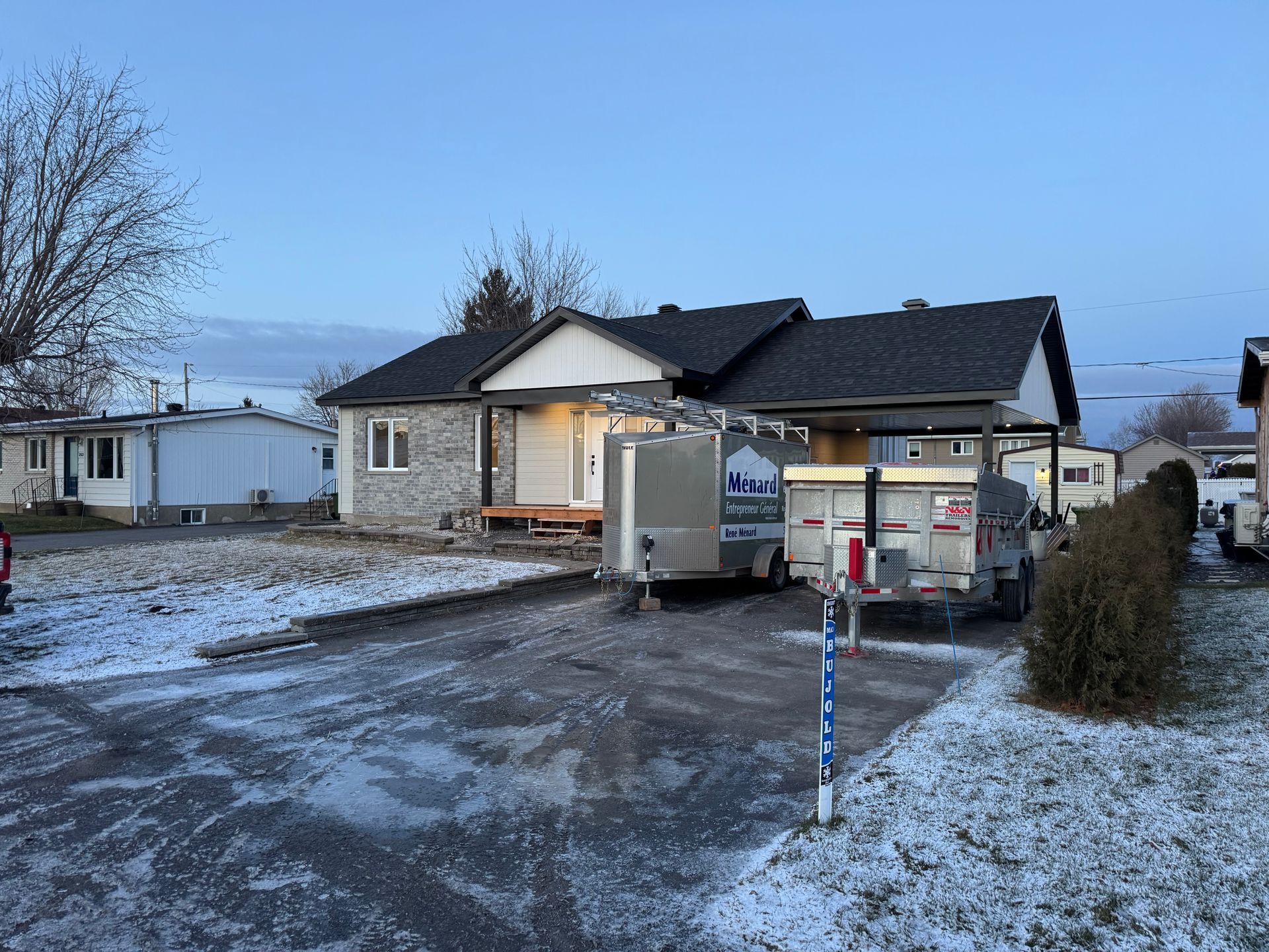 Une maison avec une caravane garée devant.