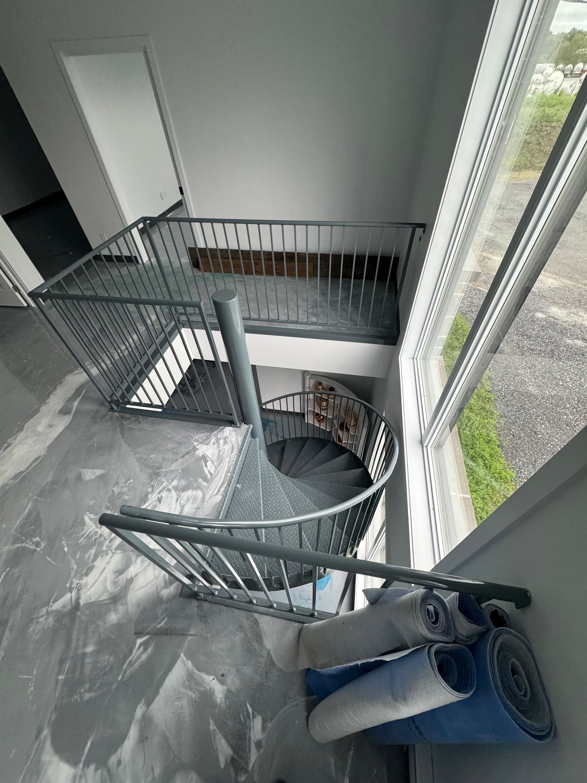 Un escalier en colimaçon monte au deuxième étage d'un immeuble.