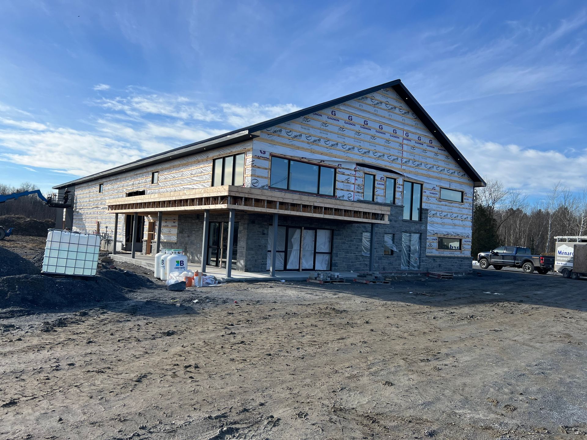 Un grand bâtiment est en construction au milieu d'un champ de terre.