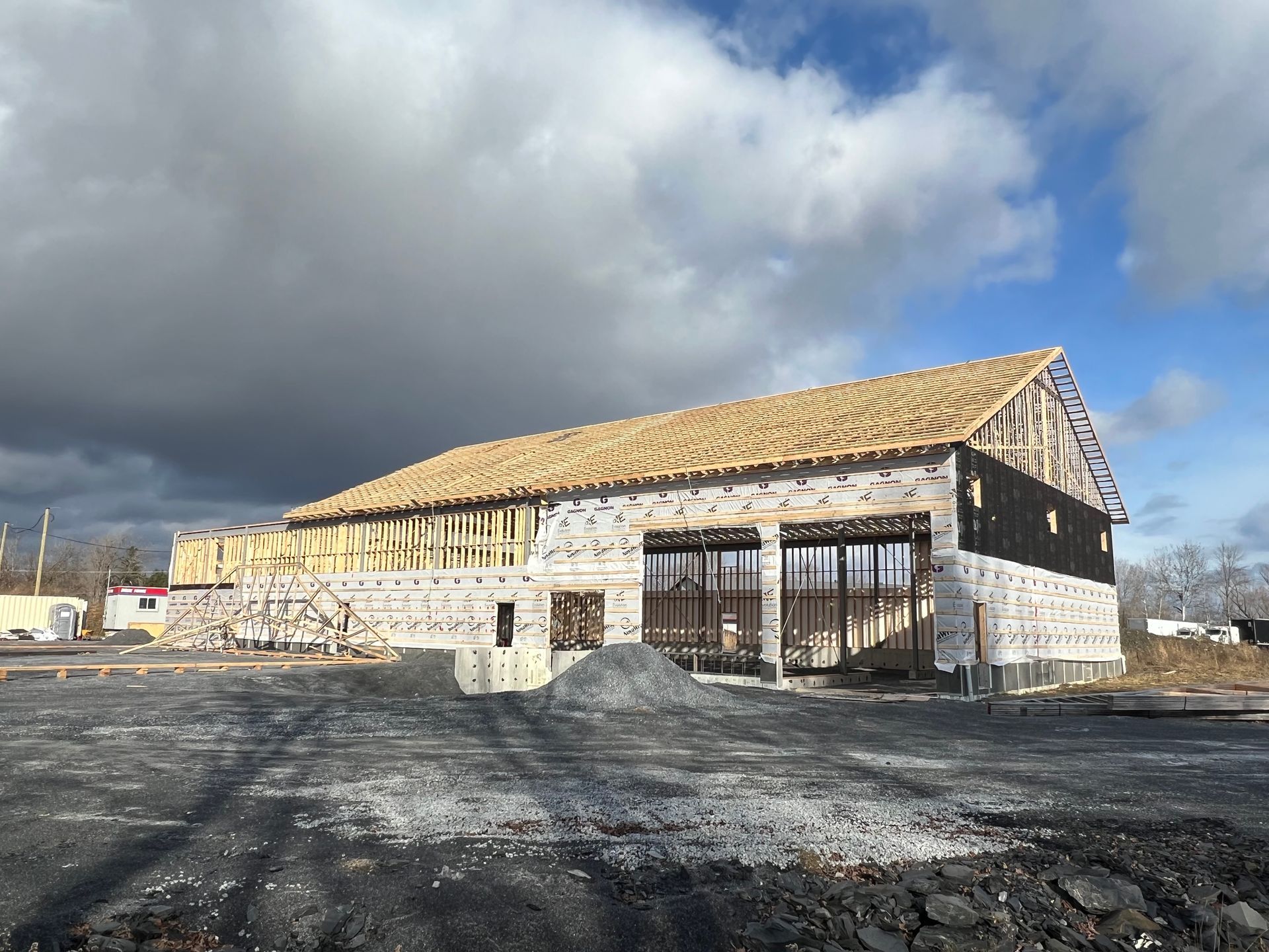 Un grand bâtiment est en construction par une journée nuageuse.