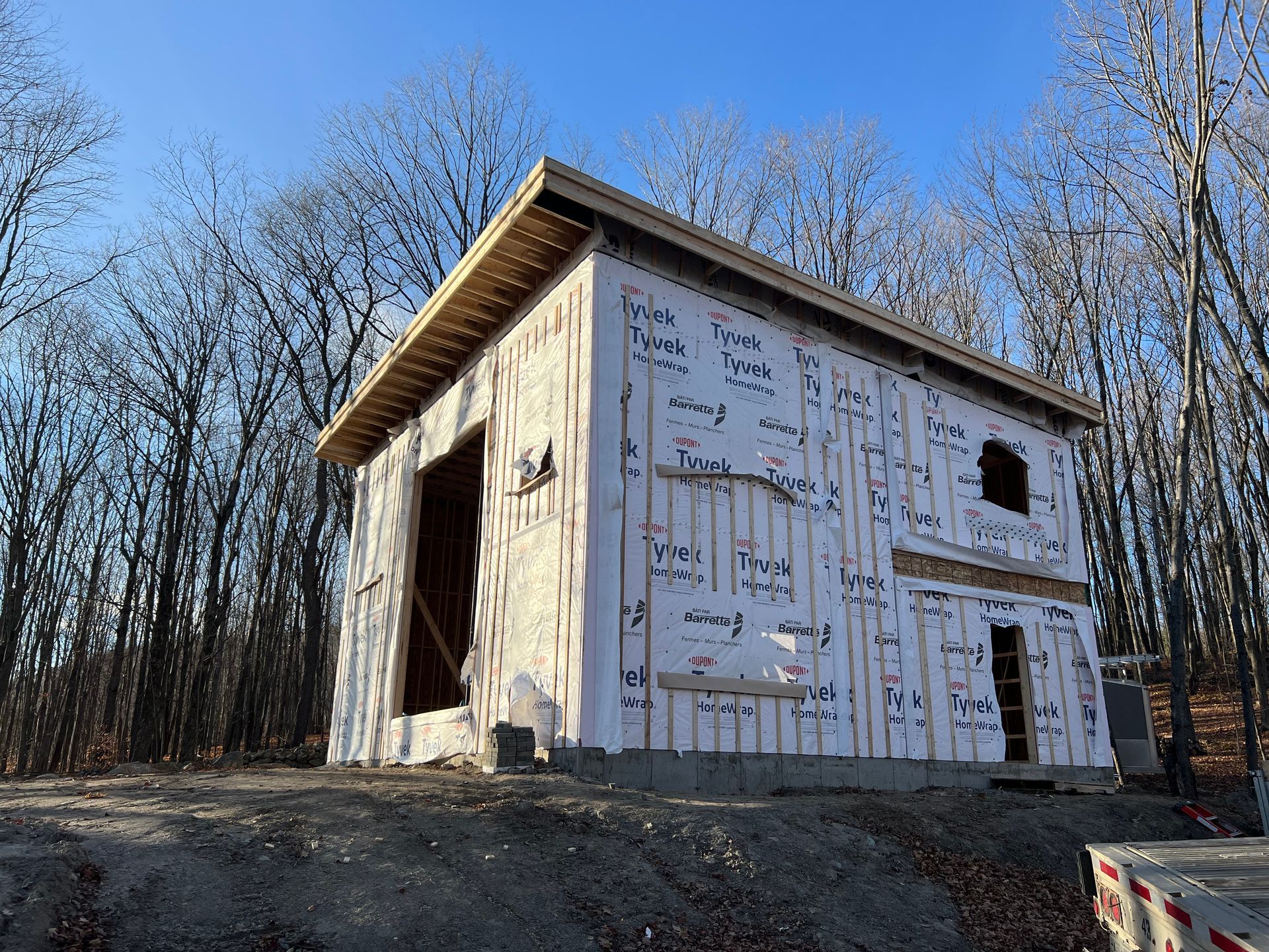Une petite maison est en construction au milieu d'une forêt.