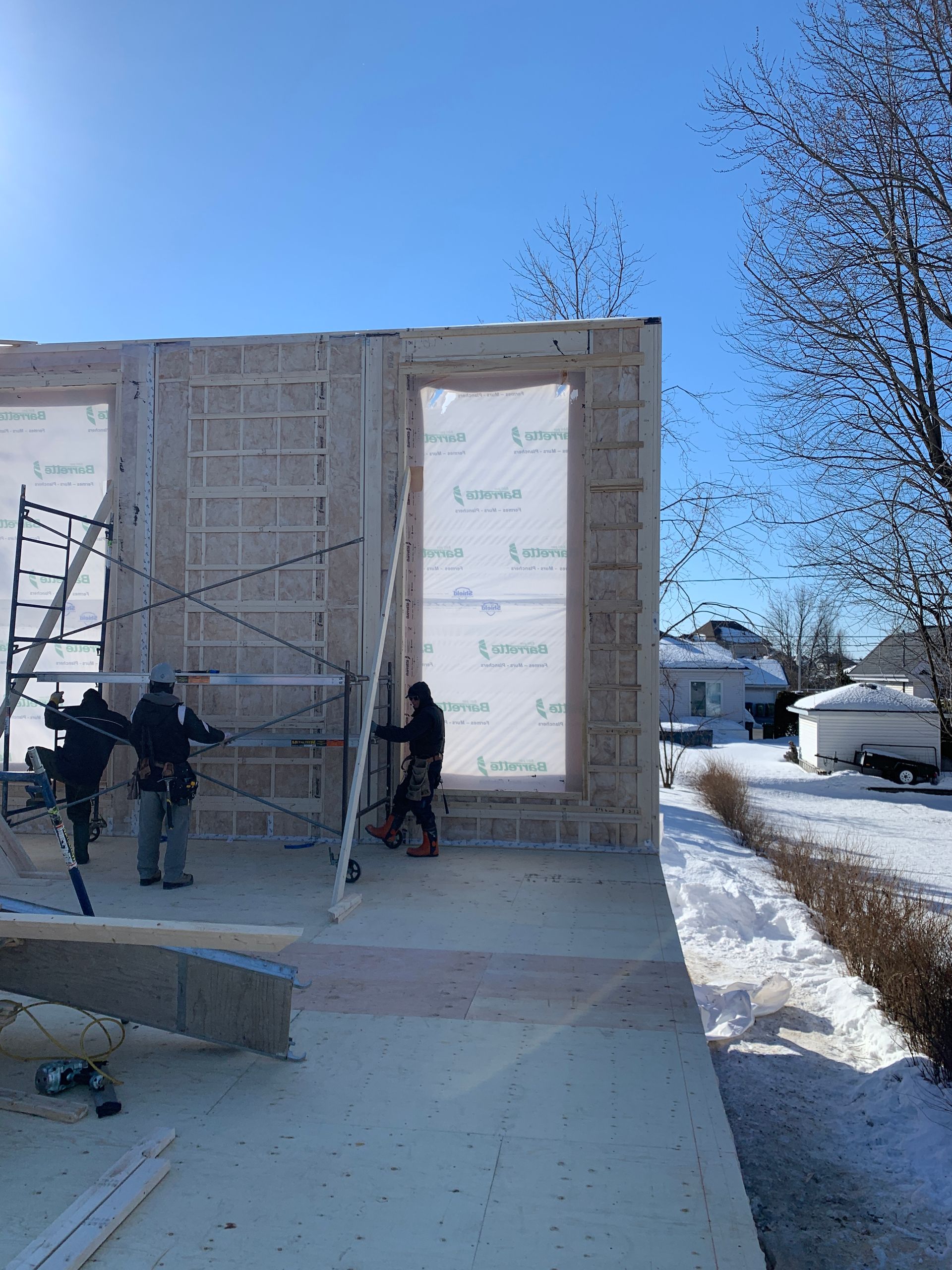 Un groupe de personnes se tient devant un bâtiment en construction.