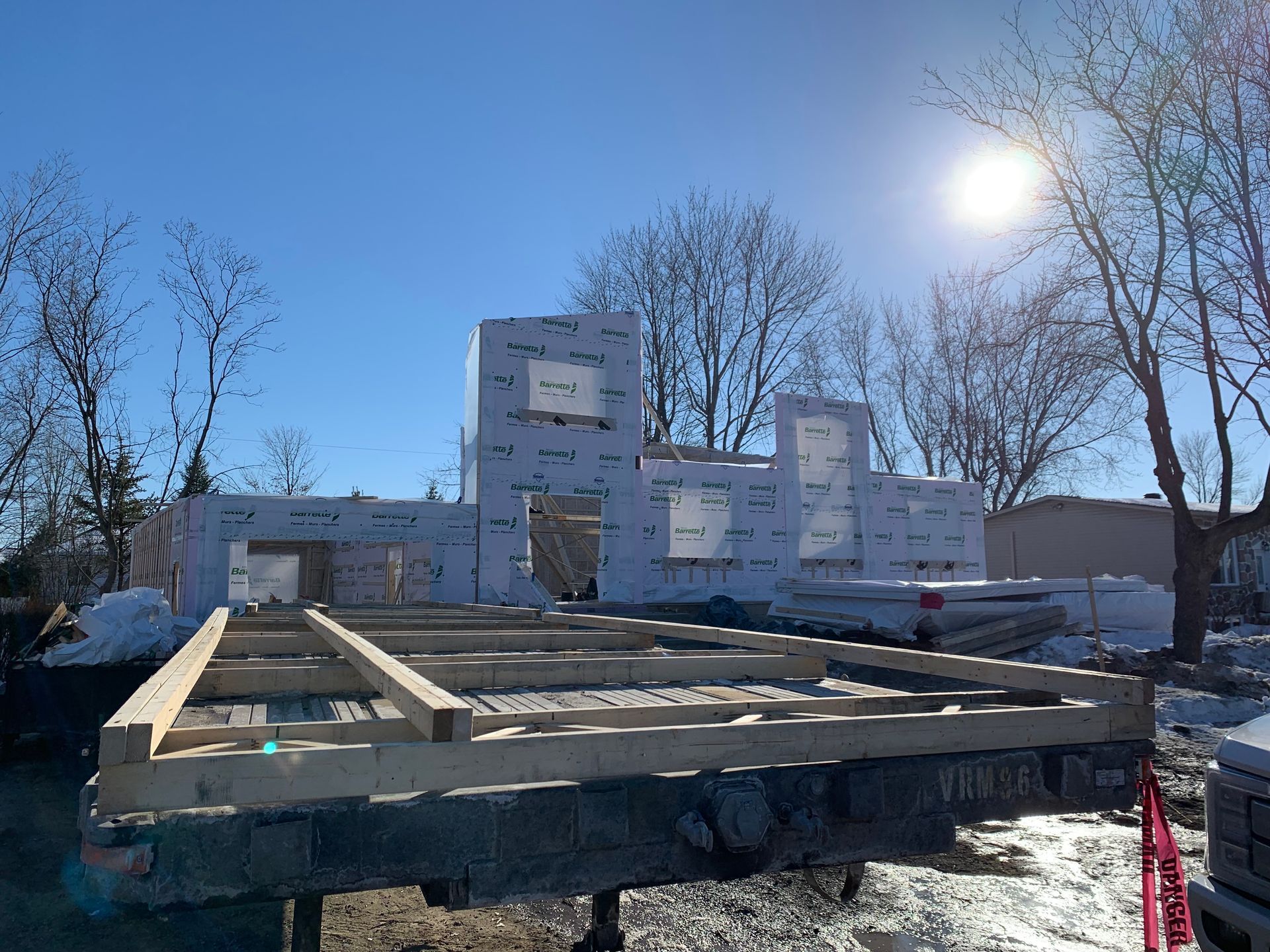 Une maison est en construction sur une remorque dans la neige.