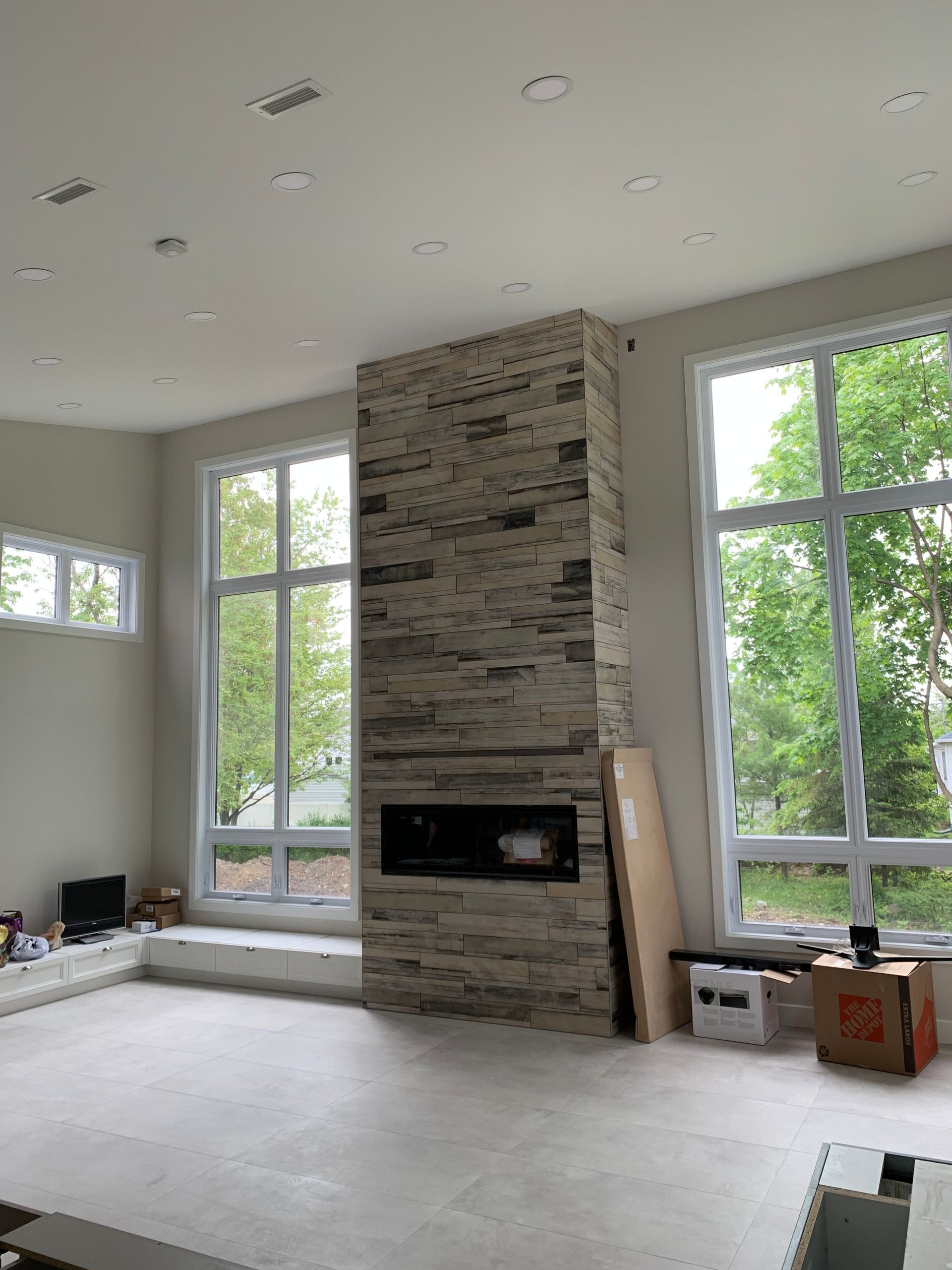 Un salon avec cheminée et beaucoup de fenêtres.