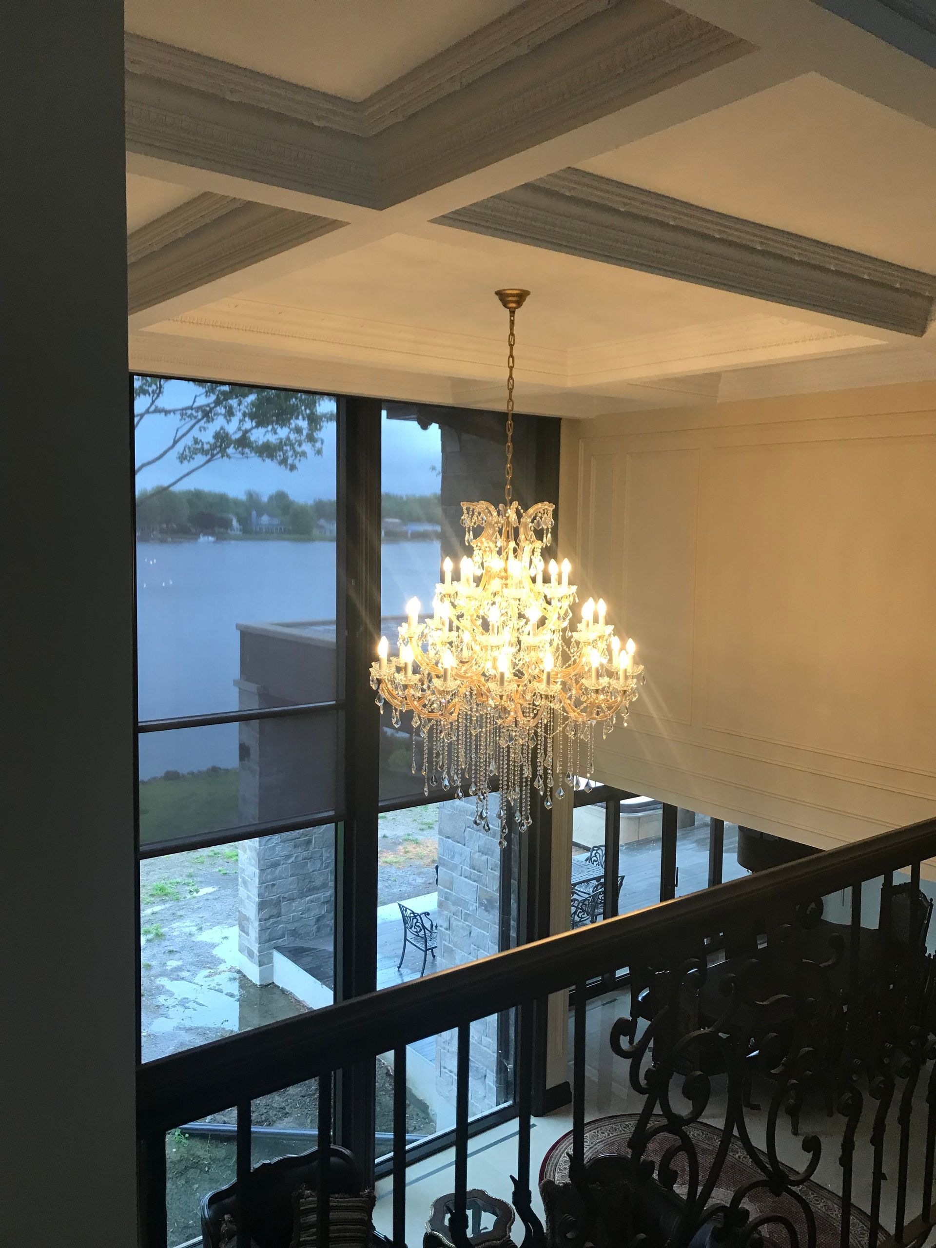 Un lustre est suspendu au plafond dans une pièce avec vue sur un lac.