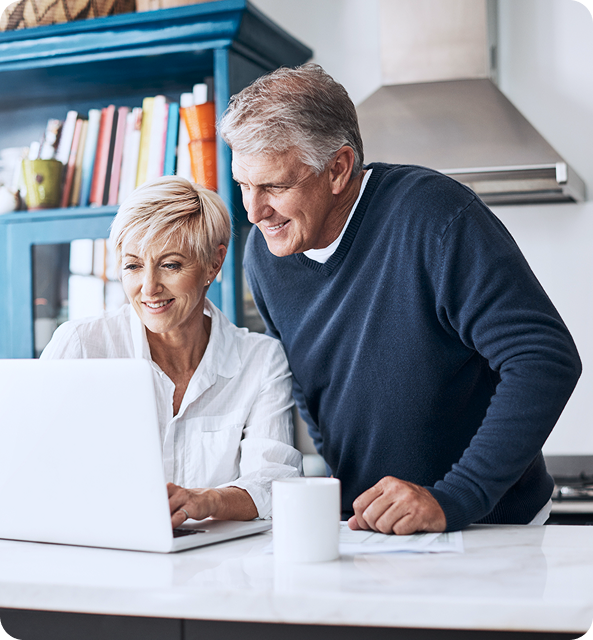 A man and a woman are looking at a laptop computer.