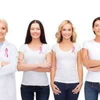 Group of smiling women in white tee shirts with pink breast cancer ribbons