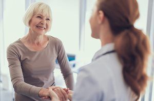 Older woman speaking with a a doctor, smiling at the doctor