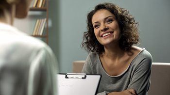 Woman speaking with a doctor while smiling