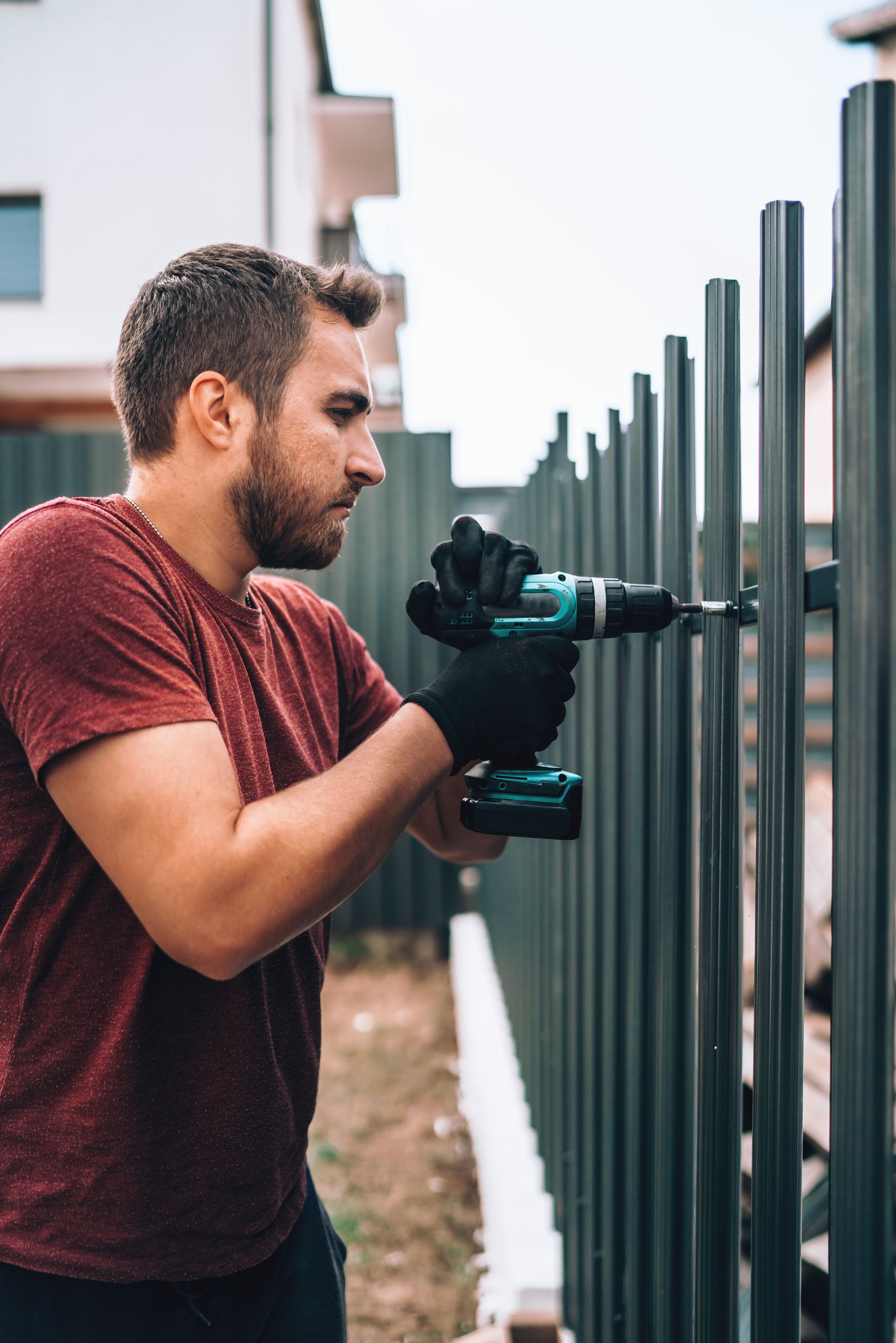 KKR worker installing metal fence outside a  home