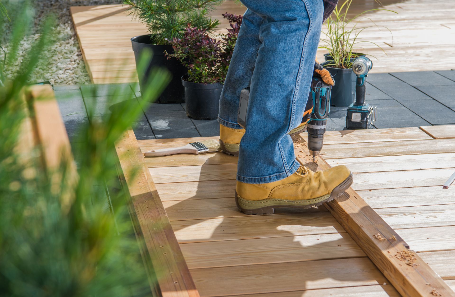 worker installing last wood plank for deck repair job