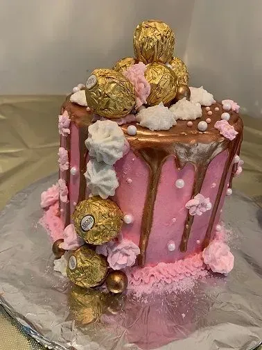 custom pink and gold cake with chocolates