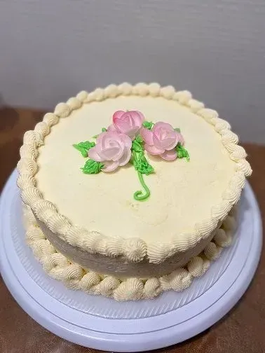 white cake with simple pink rose design