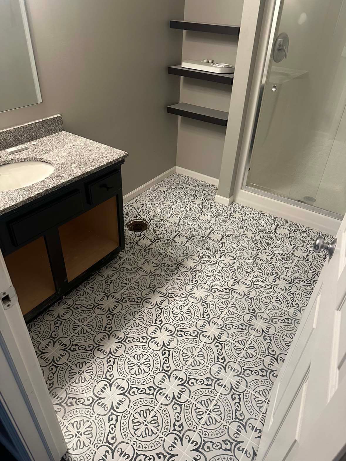 A bathroom with a sink , mirror , and shower.