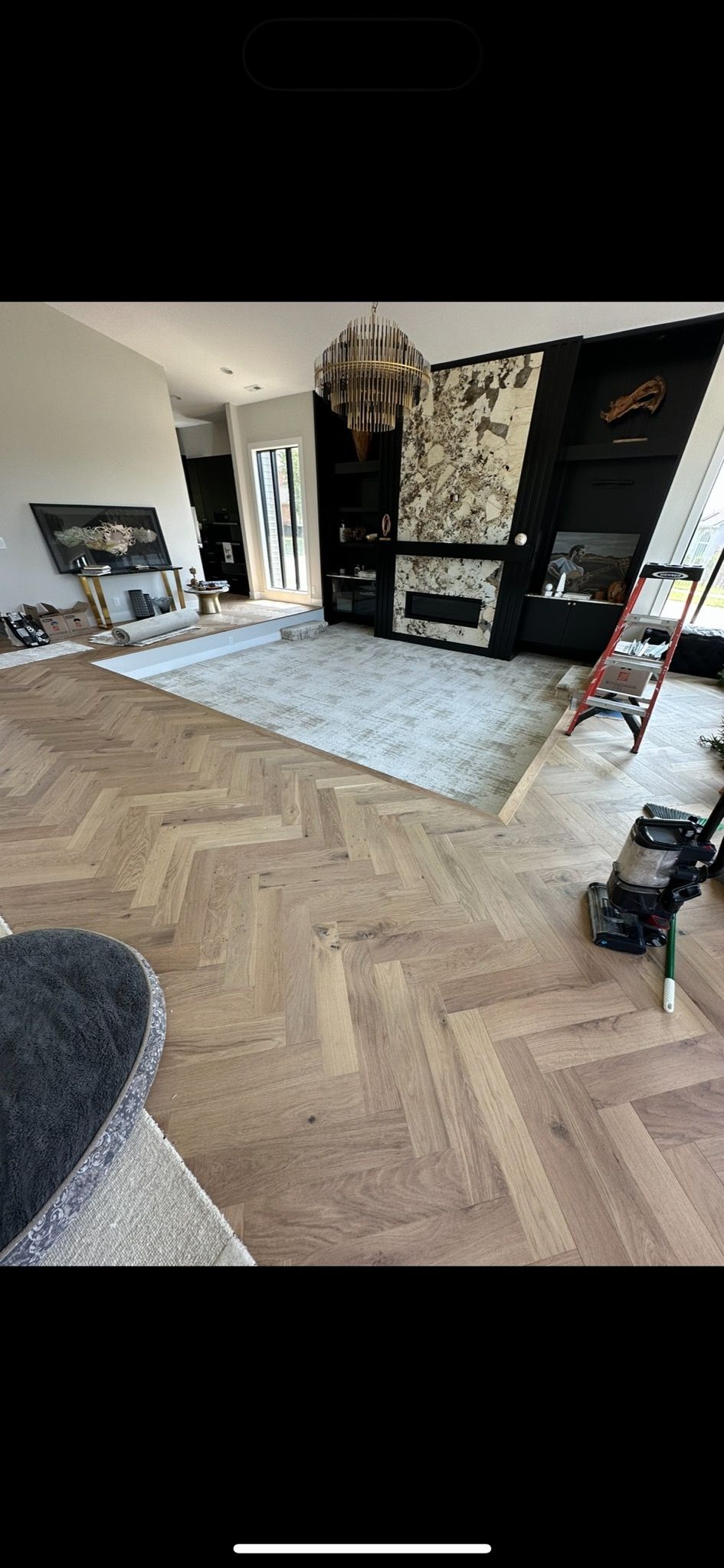 A living room with a wooden floor and a vacuum cleaner.