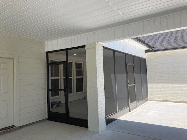 A white house with a screened in porch and a door.