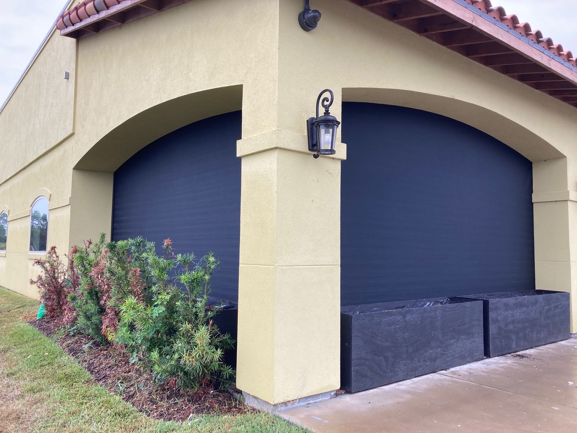 A house with a black garage door and a light on the side