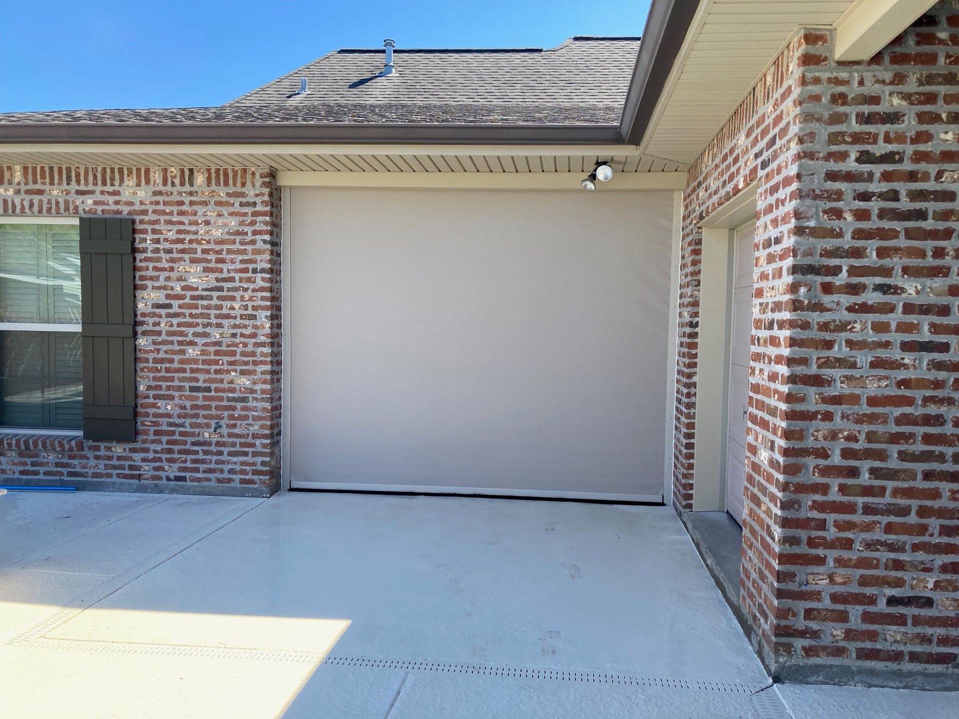 A brick house with a white garage door and a window.