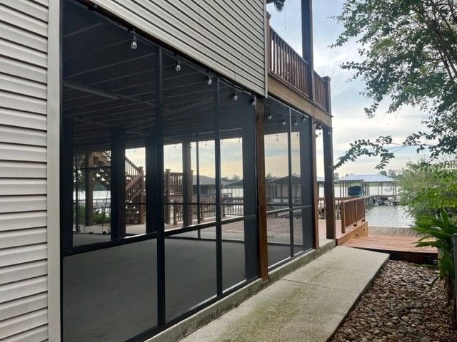A screened in porch with a view of the water