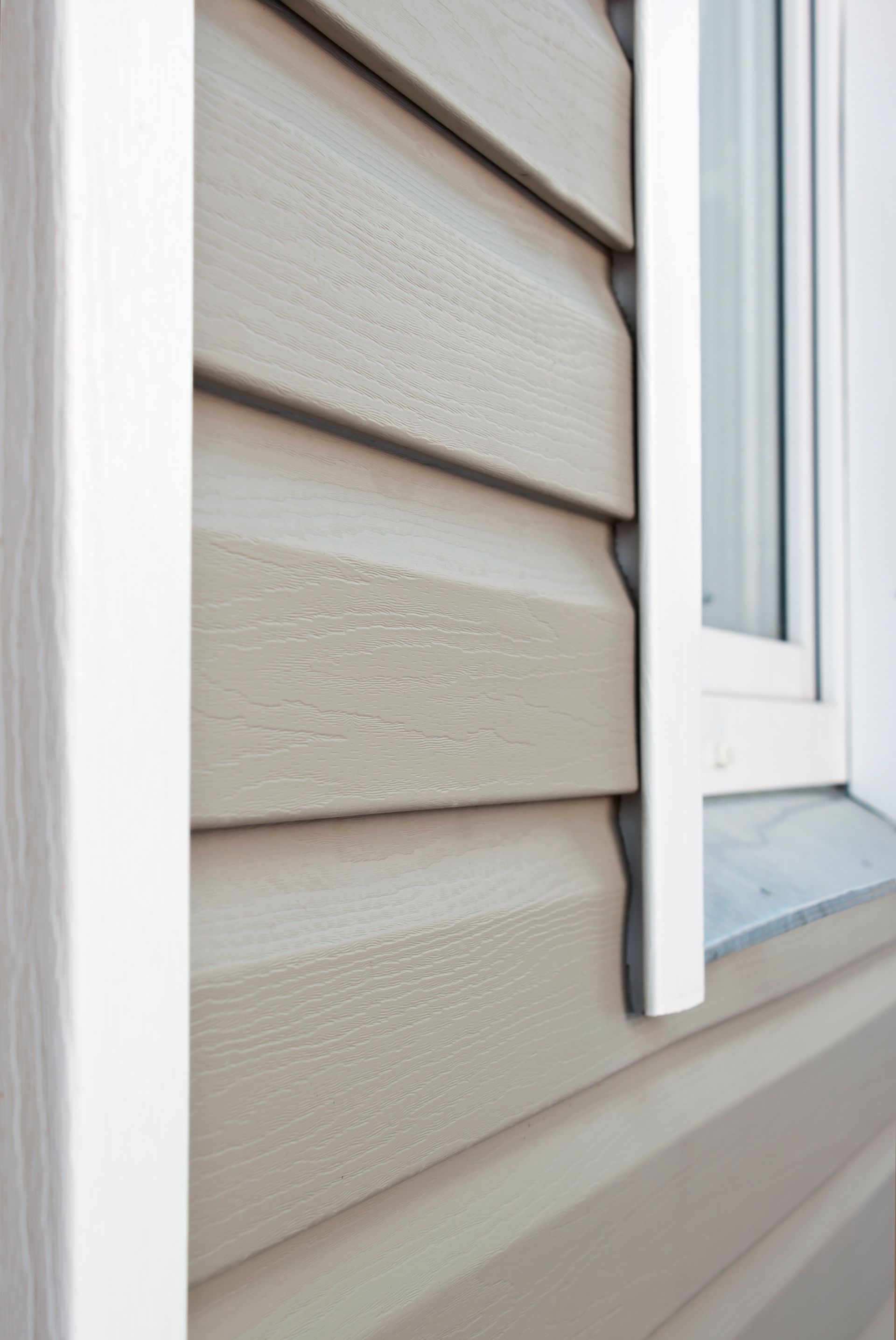A close up of a house with siding and a window.