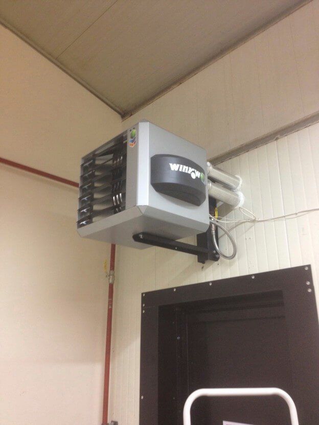 a wing heater is mounted to the ceiling above a door