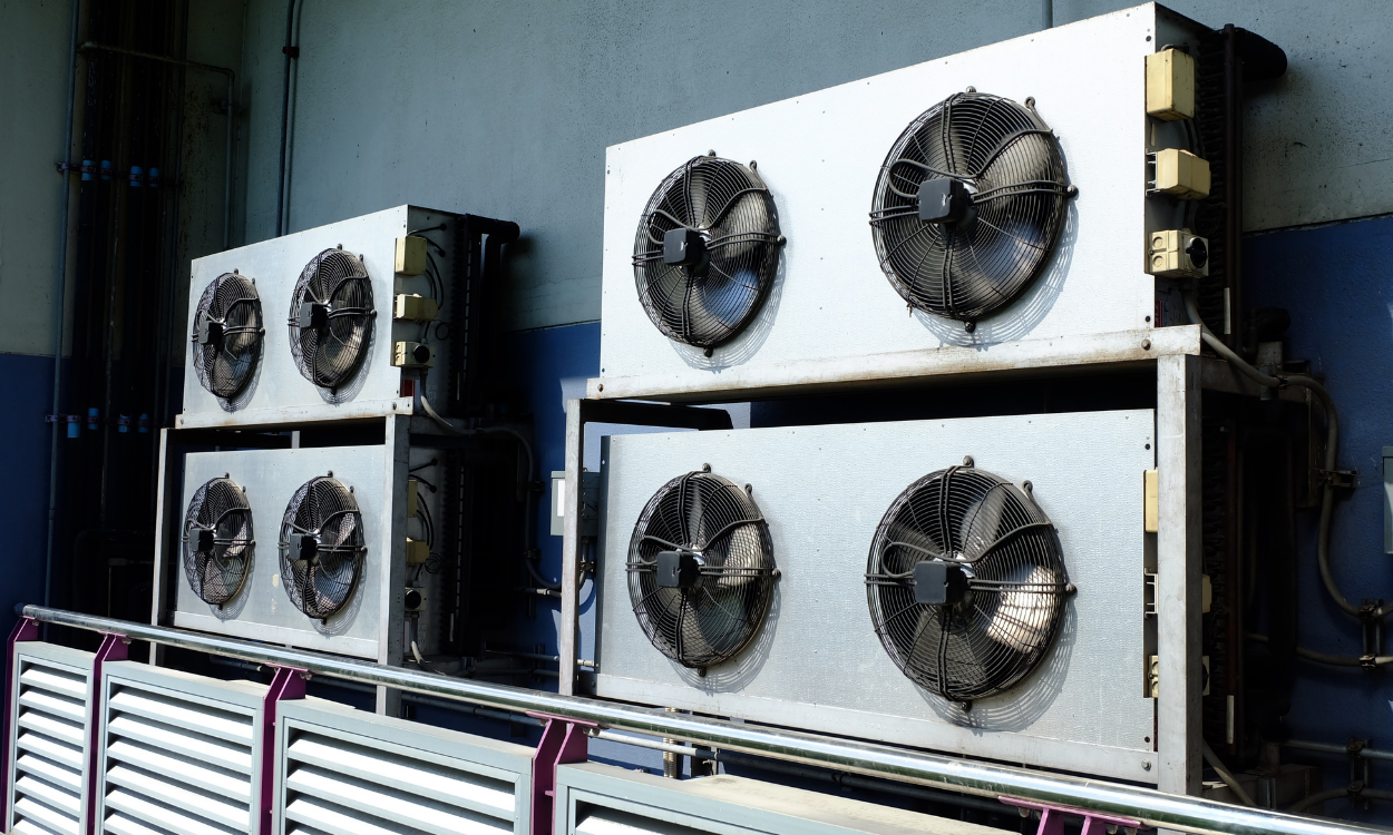 Industrial air conditioning units with fans, mounted on a wall.