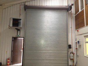 a large roller shutter is hanging from the side of a building .