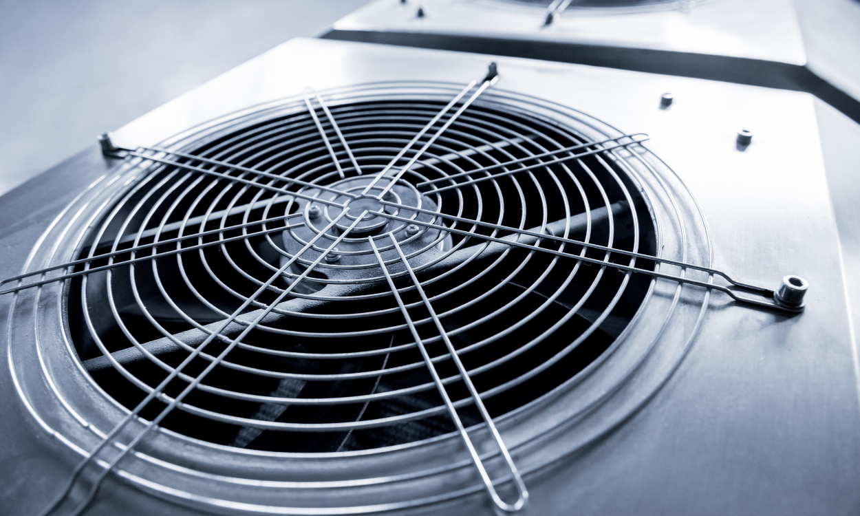 Close-up of a metal fan with a protective grill, possibly for industrial equipment.