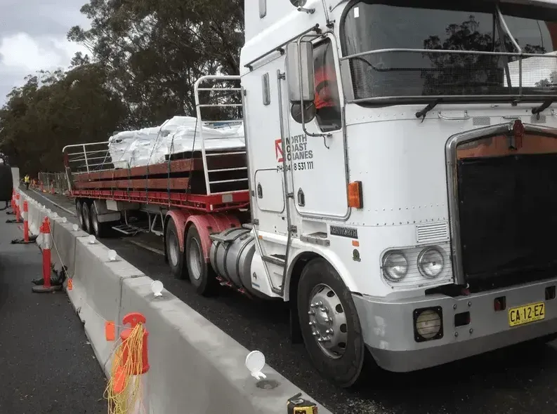 A White Semi Truck Is Driving Down a Highway — North Coast Cranes In Coffs Harbour, NSW