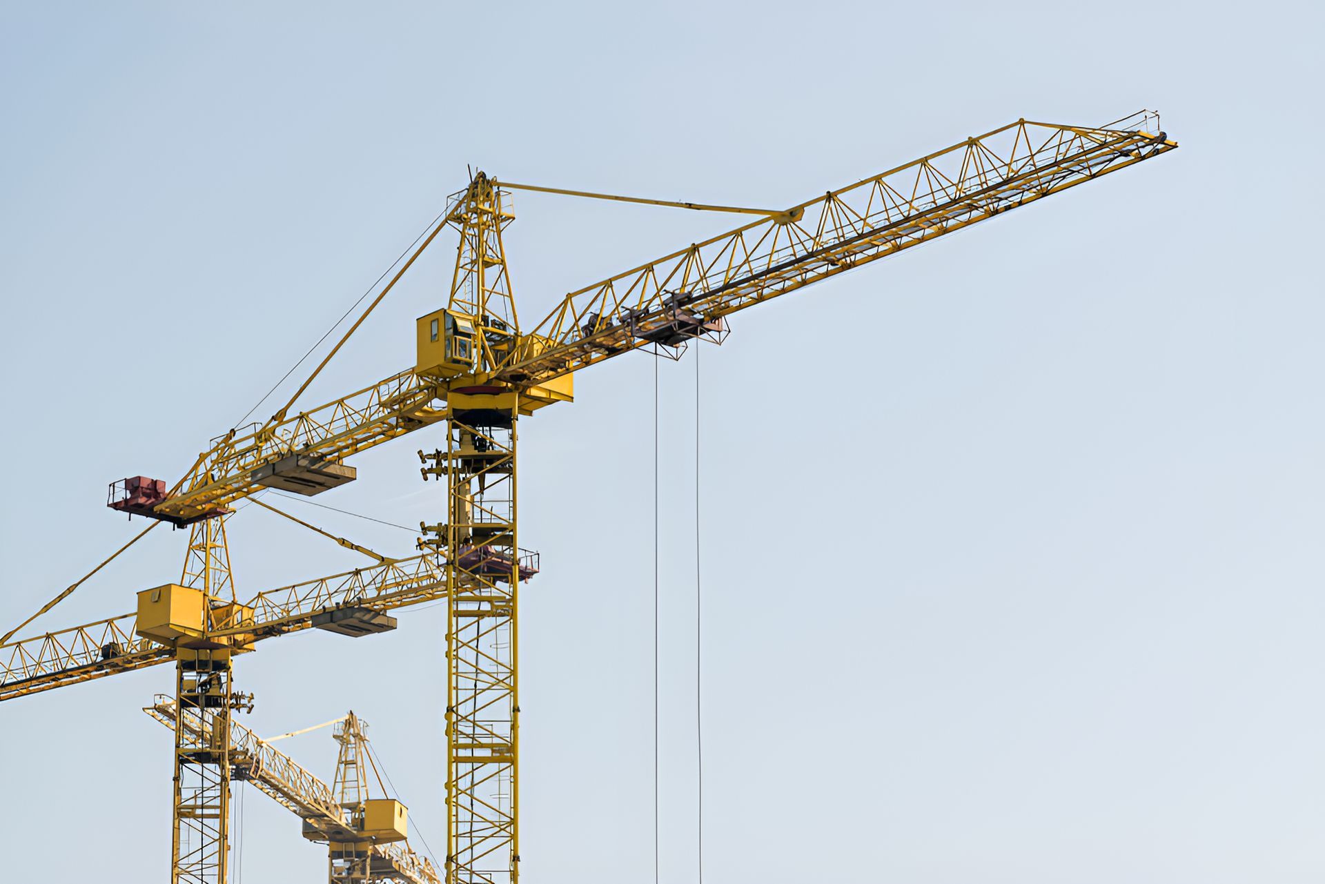 A Row Of Yellow Construction Cranes Against A Blue Sky — North Coast Cranes In Armidale, NSW