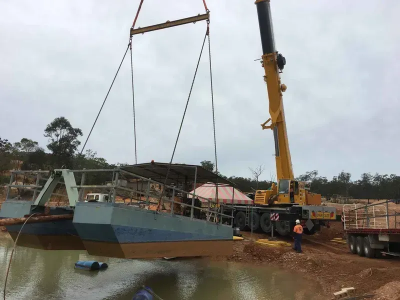 A Crane Is Lifting a Boat Into the Water — North Coast Cranes In Coffs Harbour, NSW