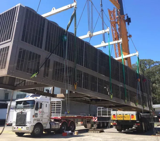 A Truck Is Being Lifted by A Crane in A Parking Lot — North Coast Cranes In Coffs Harbour, NSW