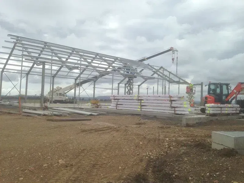 A Large Metal Structure Is Being Built in A Dirt Field — North Coast Cranes In Coffs Harbour, NSW
