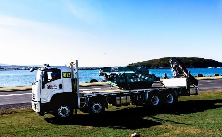 Truck Is Parked On The Side Of The Road Next To A Body Of Water  — North Coast Cranes In Coffs Harbour, NSW