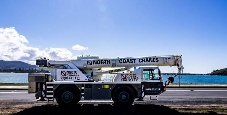 A north coast crane is parked on the side of the road.