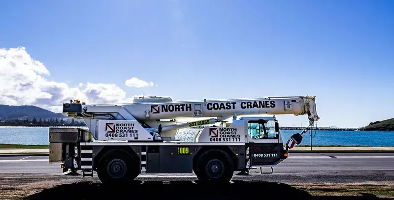 A Truck with A Crane on Top of It Parked By A Lake — North Coast Cranes In Coffs Harbour, NSW