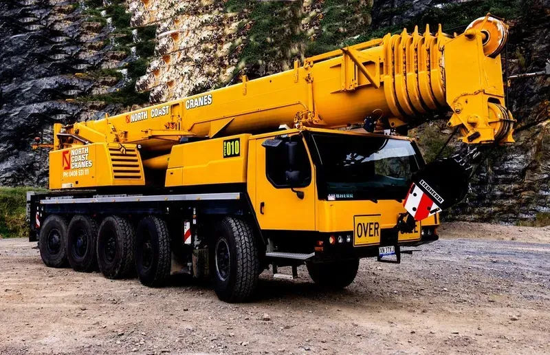 A Yellow Crane Truck with A Large Crane on A Road — North Coast Cranes In Coffs Harbour, NSW