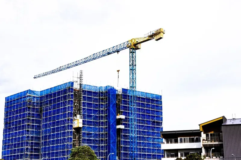 A Construction Crane Is Against a Blue Sky with Clouds — North Coast Cranes In Coffs Harbour, NSW