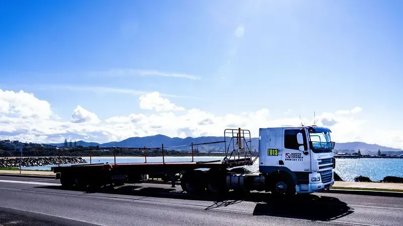 A White Truck Is Parked on The Side of The Road Next to A Body of Water — North Coast Cranes In Grafton, NSW