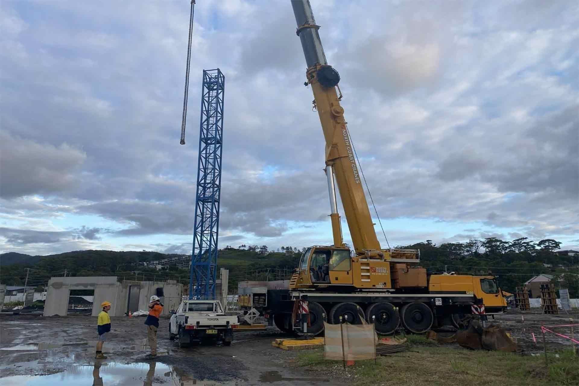 A Large Yellow Crane Is Working On A Construction Site — North Coast Cane in Coffs Harbour, NSW