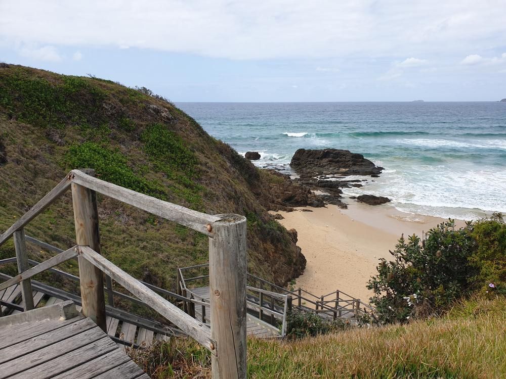 A Wooden Staircase Leading up To a Beach with A View of The Ocean — North Coast Cranes In Woolgoolga, NSW