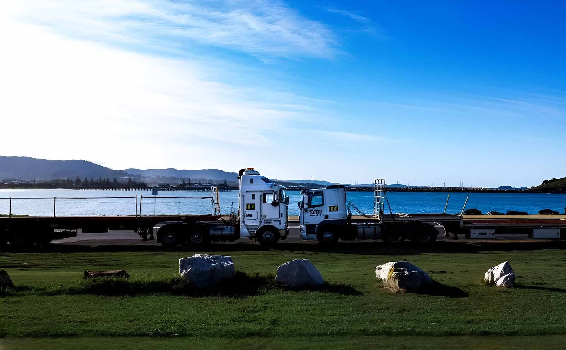 A Truck Is Parked in A Grassy Field Next to A Body of Water — North Coast Cranes In Armidale, NSW