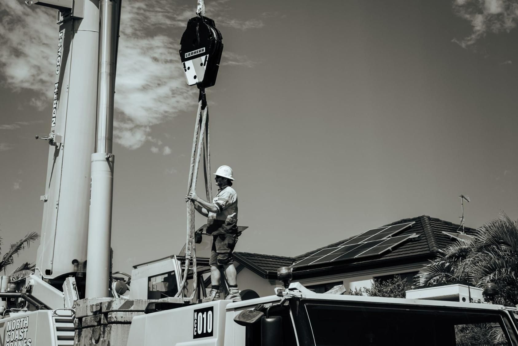 A Black And White Photo Of A Man Working On A Crane — North Coast Cranes In Coffs Harbour, NSW