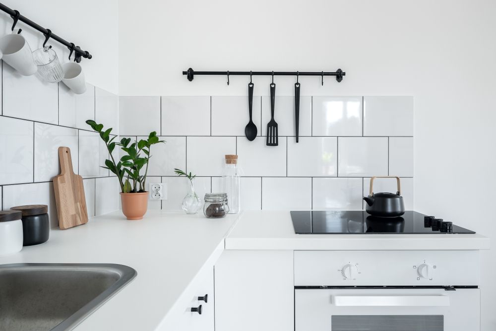 kitchen with white wall tiles and functional black hangers