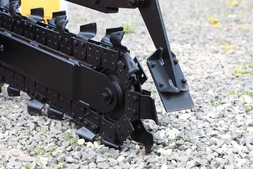 A Close up of a Chainsaw on a Gravel road — Curtis Coast Excavators in Gladstone, QLD