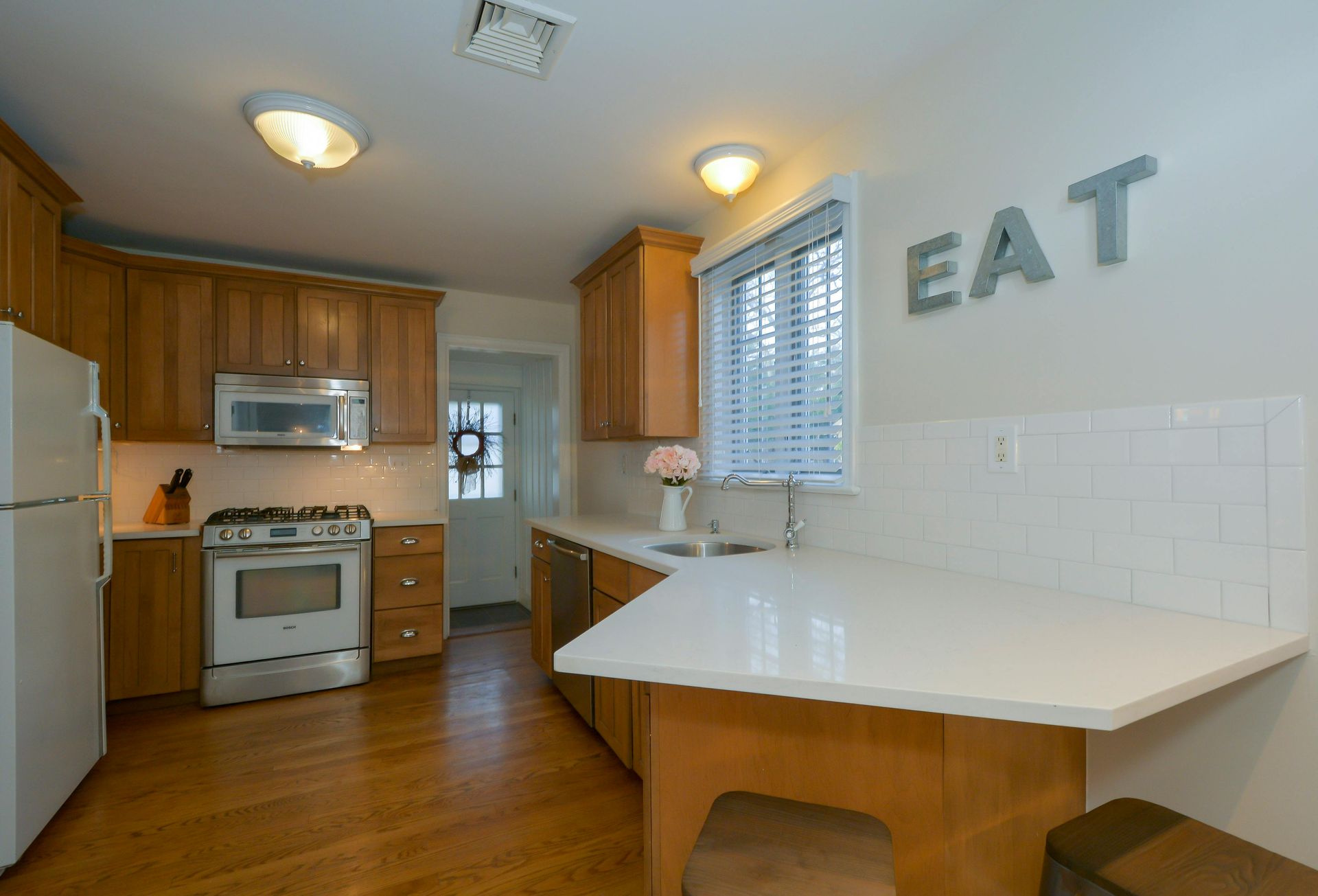 White ceiling with ventilation and a light fixture, above tan walls.