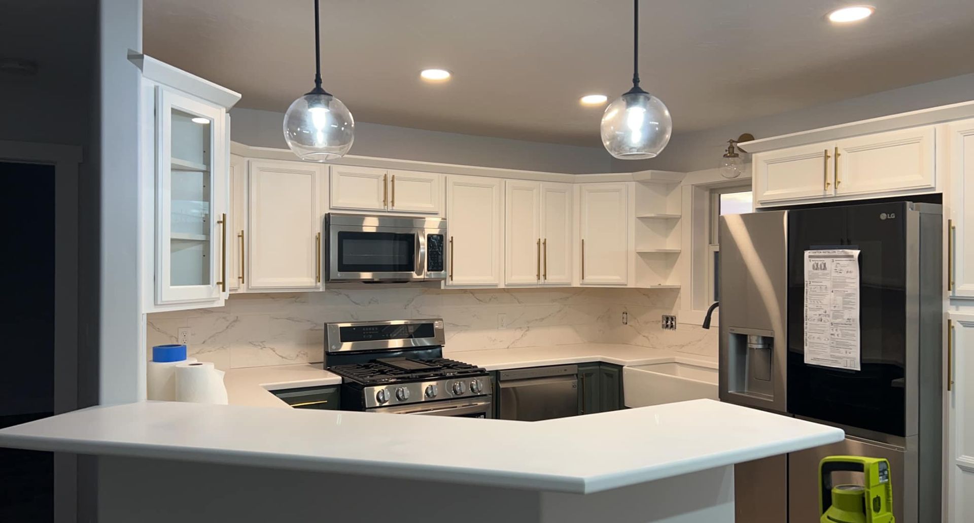 Kitchen with white cabinets, stainless steel appliances, and a white countertop.