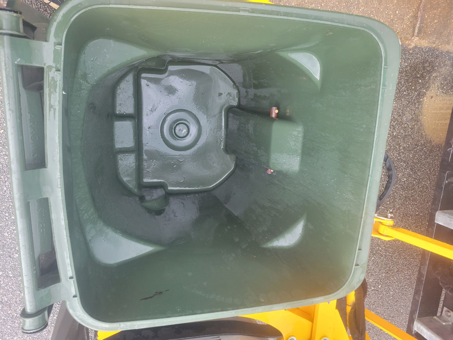 A man is putting trash into a trash can on the sidewalk.